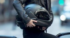 mujer sosteniendo casco de motociclista